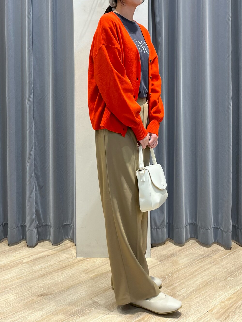 ベージュ系のパンツ、ホワイト系のその他シューズ、ホワイト系のハンドバッグを着用したレディースの冬コーディネートの2枚目の写真