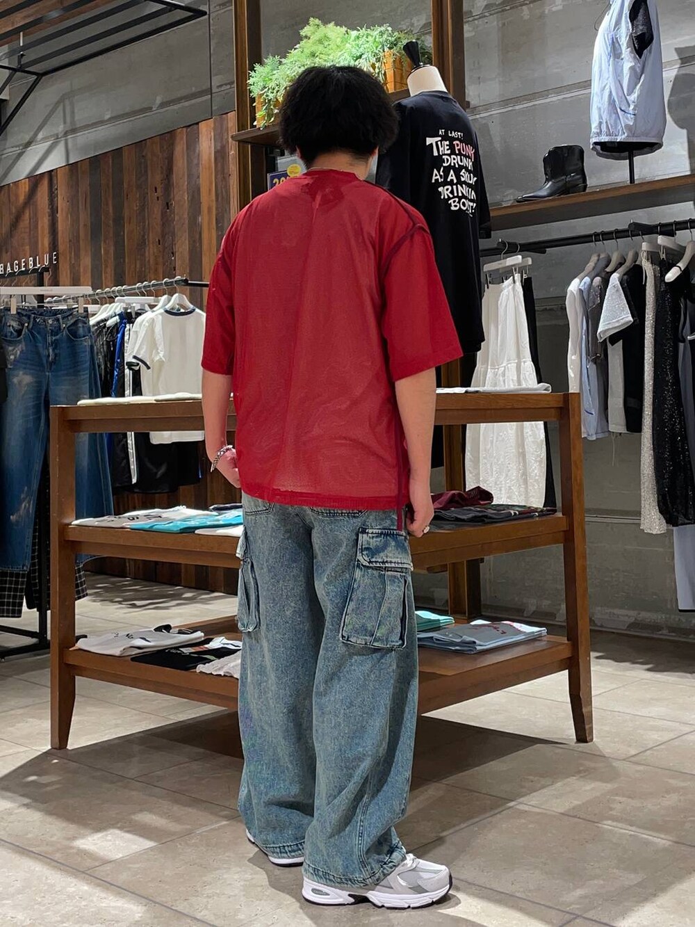 ブルー系のデニムパンツ、グレー系のスニーカー、レッド系のTシャツ/カットソーを着用したメンズの夏コーディネートの3枚目の写真