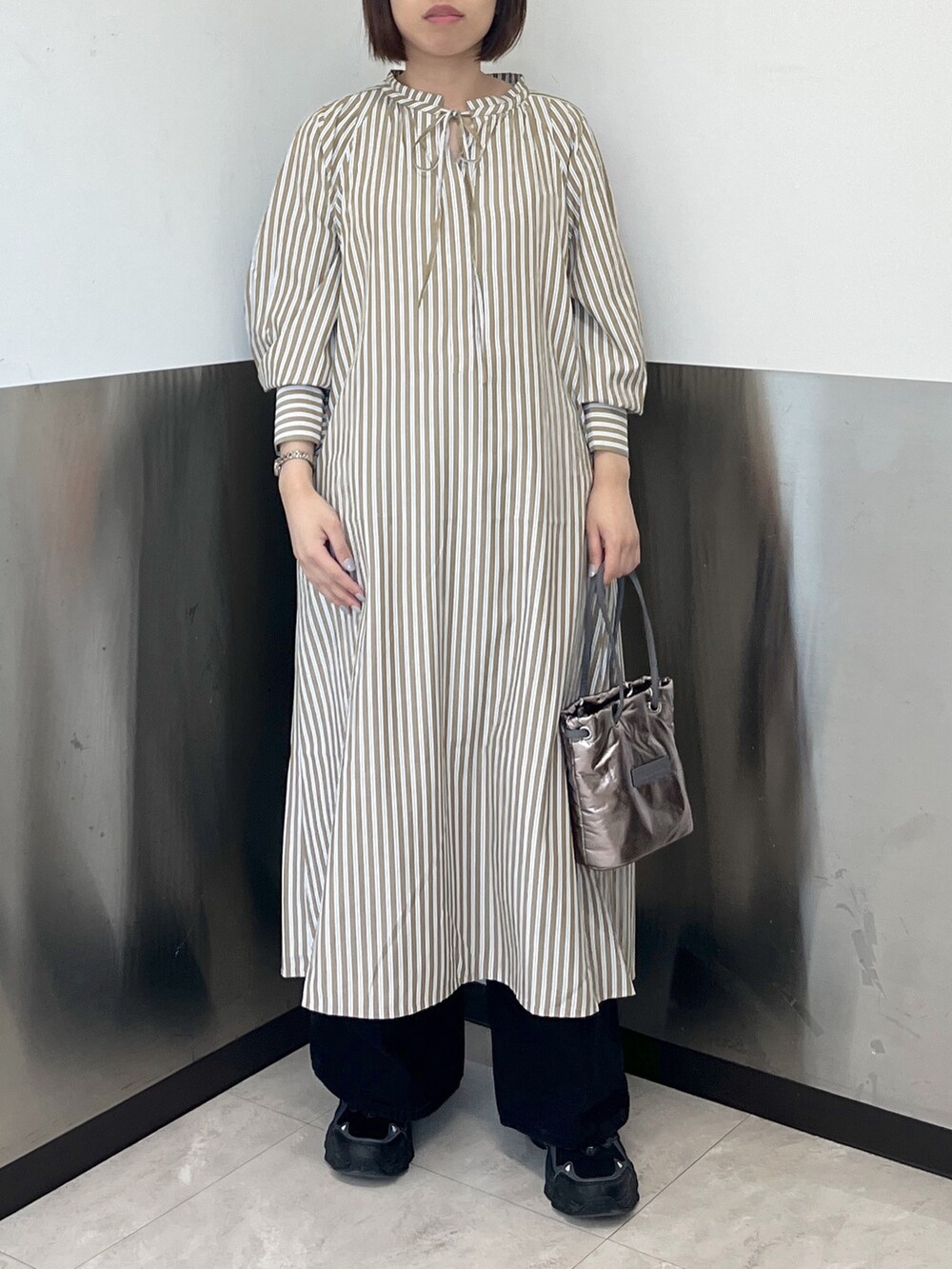 ブラック系のデニムパンツ、ベージュ系のパーカー、ベージュ系のシャツワンピースを着用したレディースの冬コーディネートの4枚目の写真