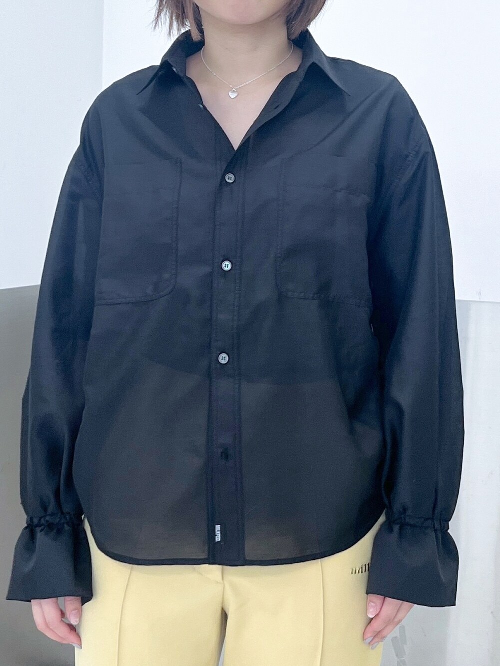 ブラック系のシャツ/ブラウス、グリーン系のハンドバッグ、イエロー系のその他パンツを着用したレディースの春コーディネートの4枚目の写真