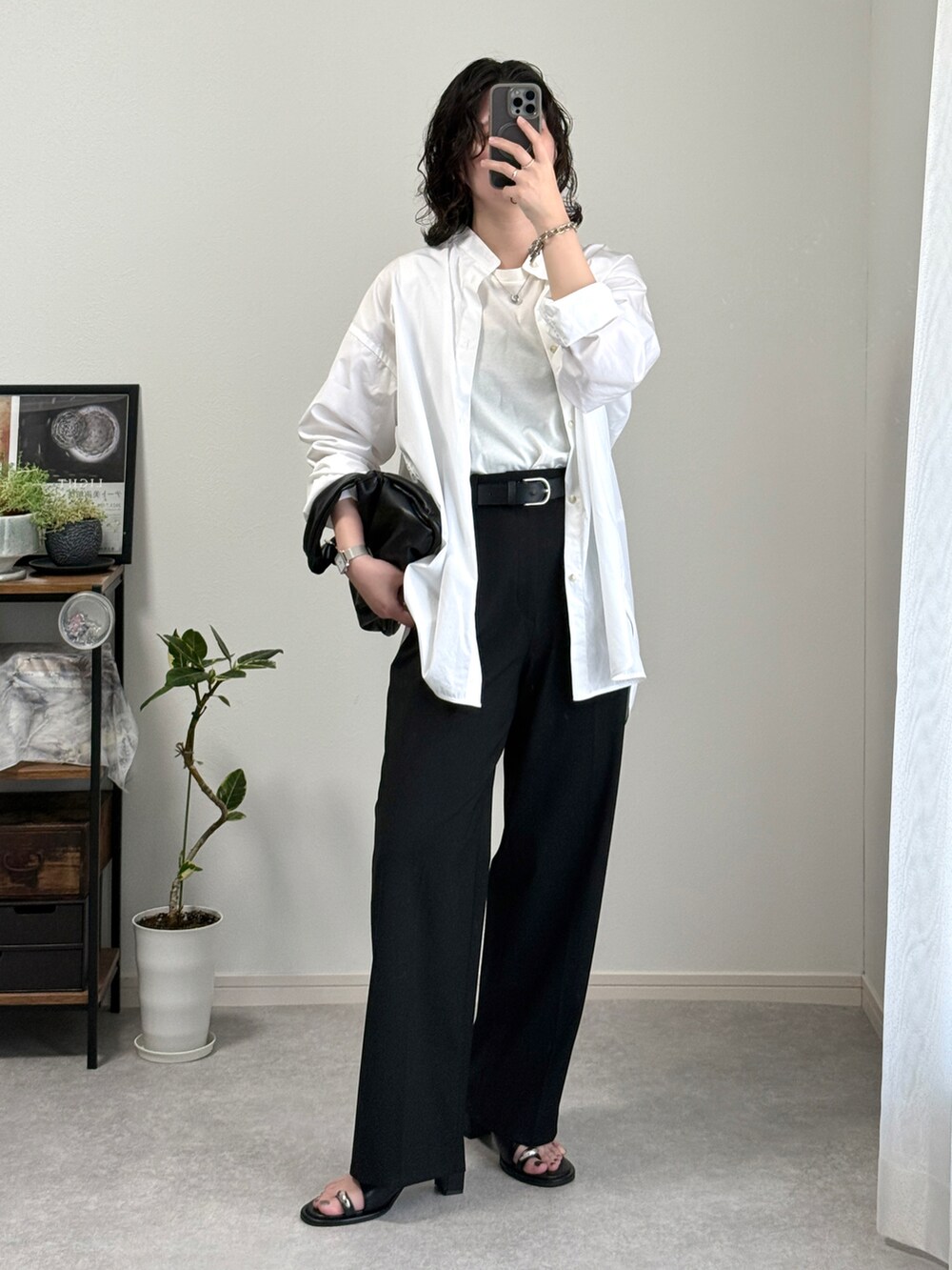 ブラック系のスラックス、ブラック系のサンダル、ブラック系のハンドバッグを着用したレディースの春コーディネートの4枚目の写真