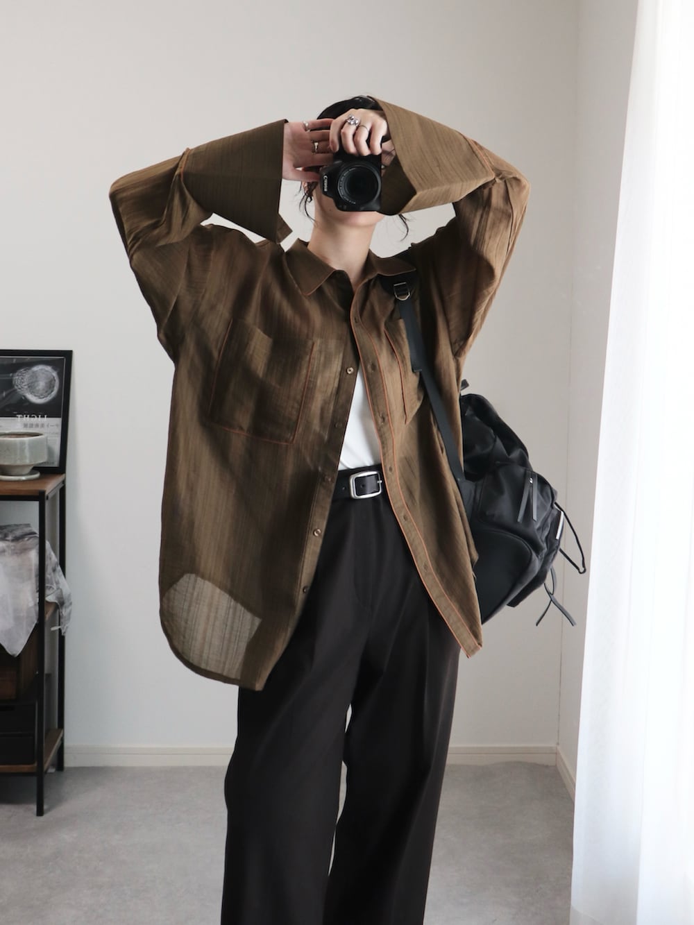 ブラック系のブーツ、ブラウン系のシャツ/ブラウス、ブラック系のバックパック/リュックを着用したレディースの夏コーディネートの3枚目の写真