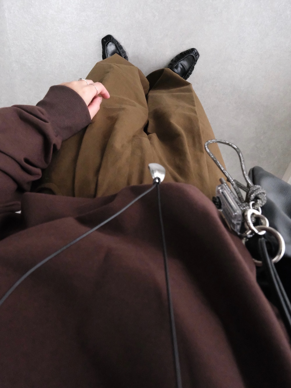 ブラウン系のスウェット、ブラウン系のその他パンツ、ブラック系のハンドバッグを着用したレディースの秋コーディネートの4枚目の写真