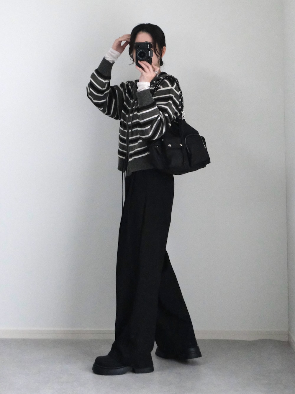 グレー系のパーカー、ブラック系のブーツ、ブラック系のTシャツ/カットソーを着用したレディースの秋コーディネートの3枚目の写真