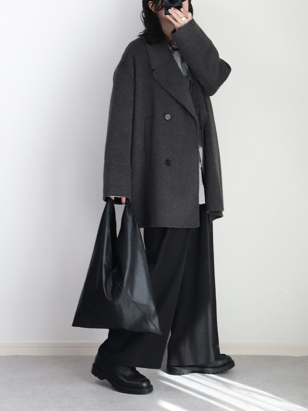 グレー系のベスト、ホワイト系のシャツ/ブラウス、ブラック系のその他パンツを着用したレディースの冬コーディネートの5枚目の写真