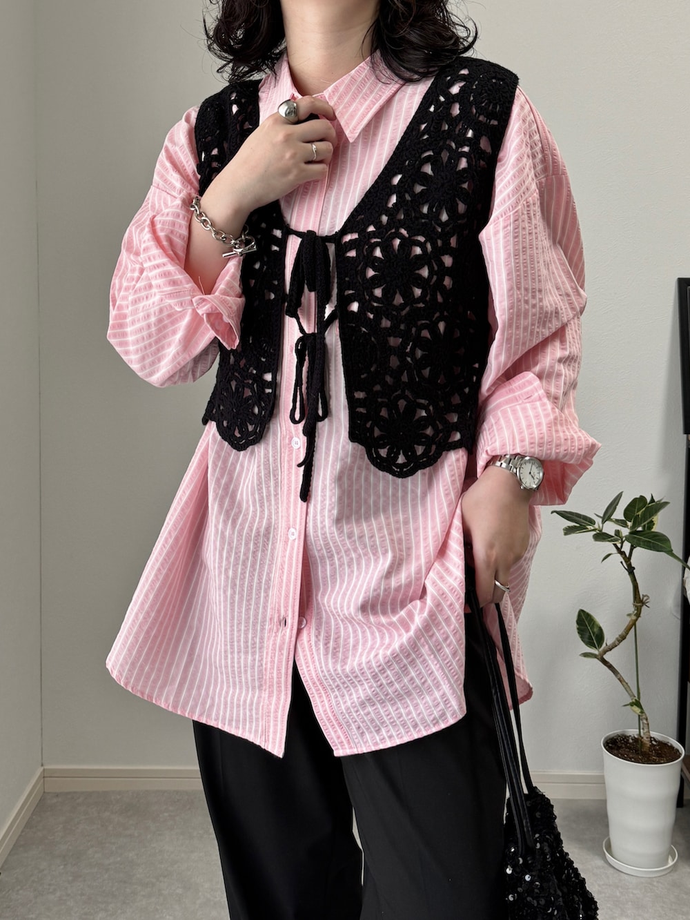 ブラック系のスラックス、ブラック系のサンダル、シルバー系のショルダーバッグを着用したレディースの夏コーディネートの3枚目の写真