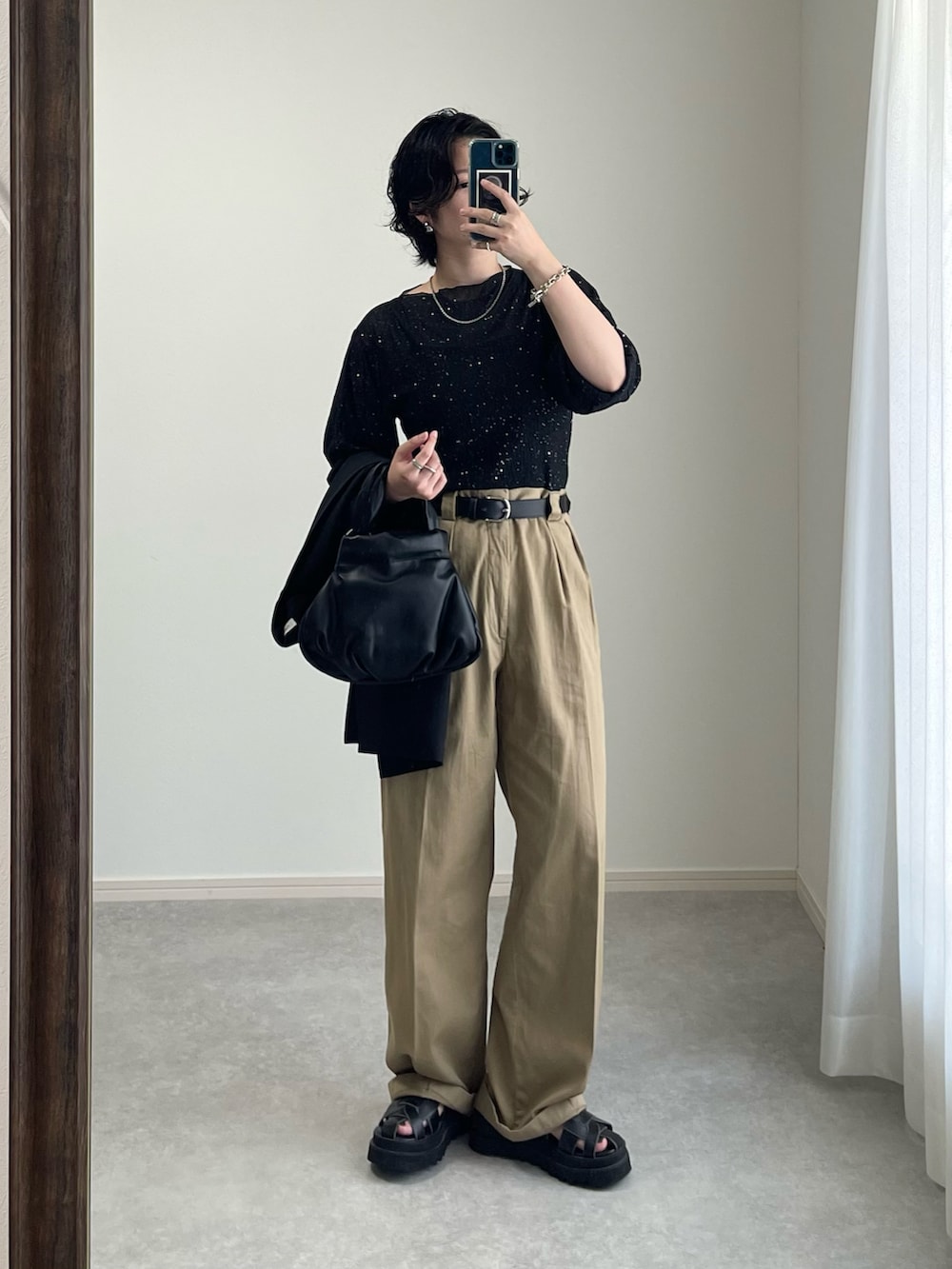 ブラック系のサンダル、ベージュ系のチノパンツ、ブラック系のハンドバッグを着用したレディースの夏コーディネートの2枚目の写真