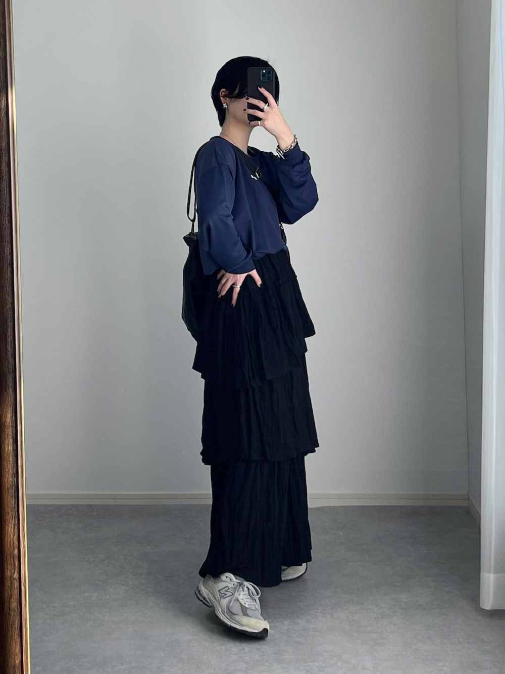 ブラック系のスカート、グレー系のスニーカー、ブラック系のトートバッグを着用したレディースの春コーディネートの3枚目の写真