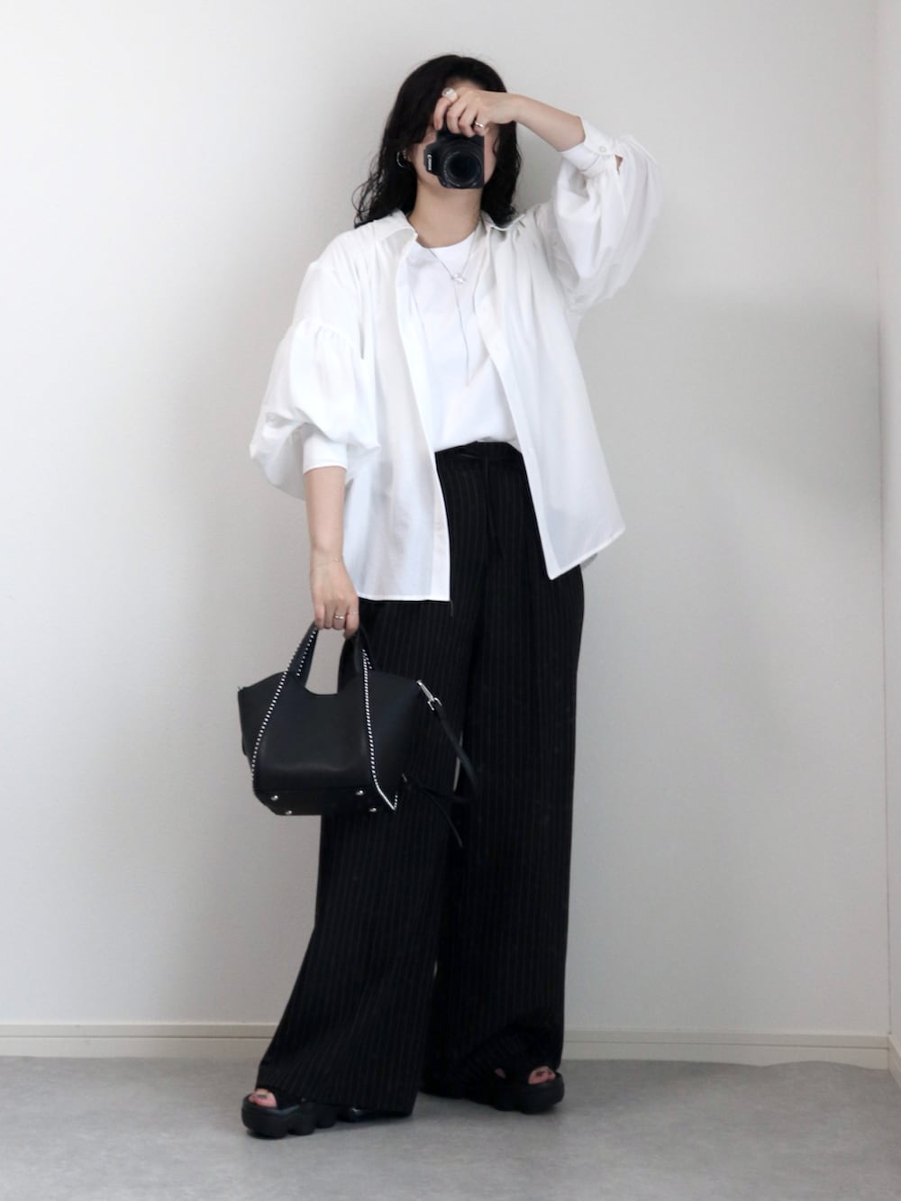 ホワイト系のシャツ/ブラウス、ブラック系のサンダル、ブラック系のスラックスを着用したレディースの夏コーディネートの2枚目の写真