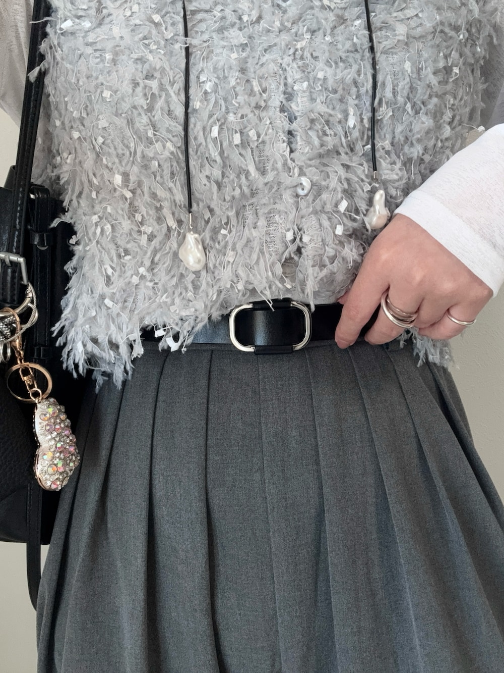 グレー系のスラックス、グレー系のベスト、ホワイト系のTシャツ/カットソーを着用したレディースの春コーディネートの4枚目の写真