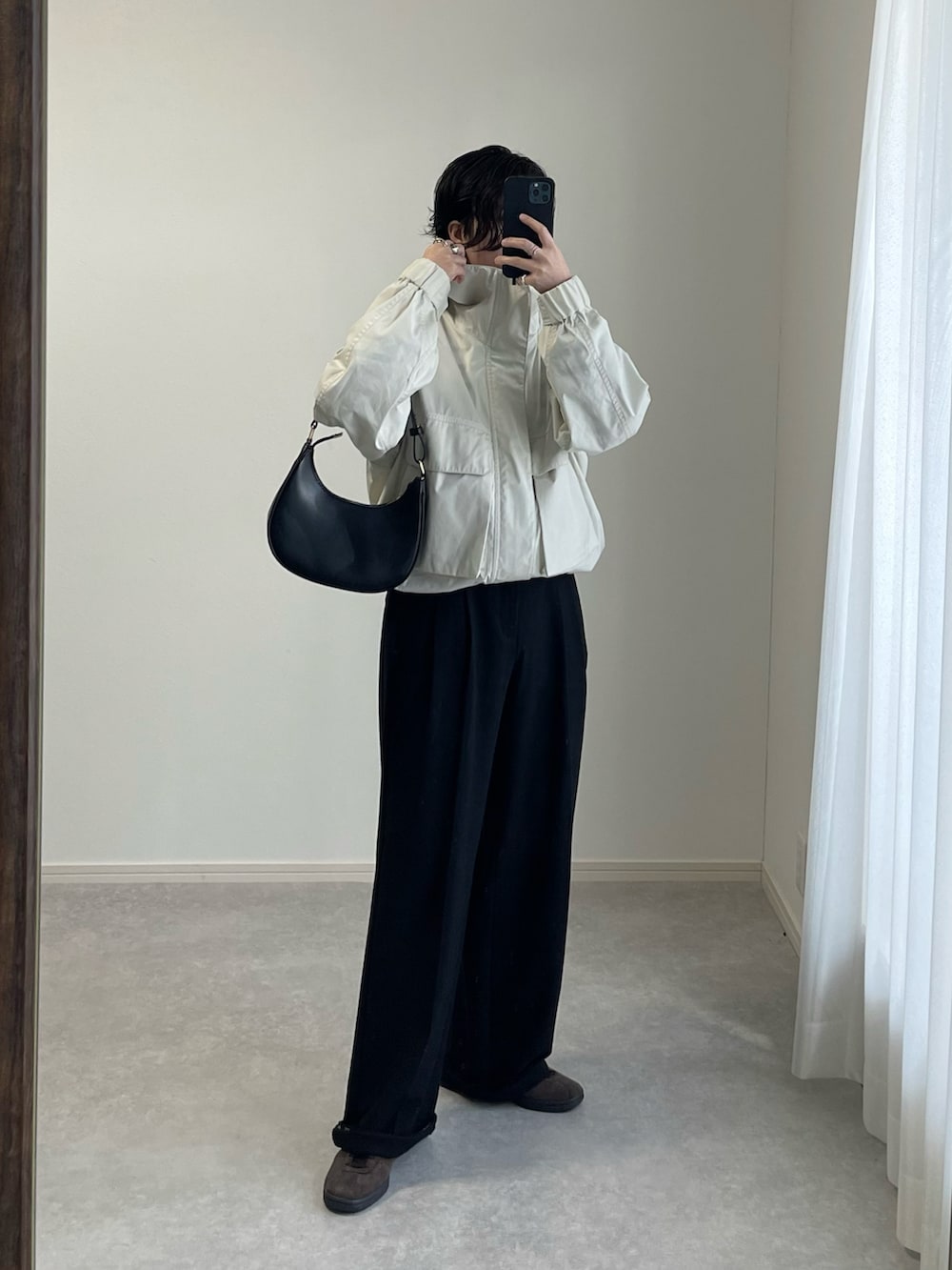 グレー系のスラックス、ブルー系のTシャツ/カットソー、ホワイト系のブルゾンを着用したレディースの春コーディネートの4枚目の写真