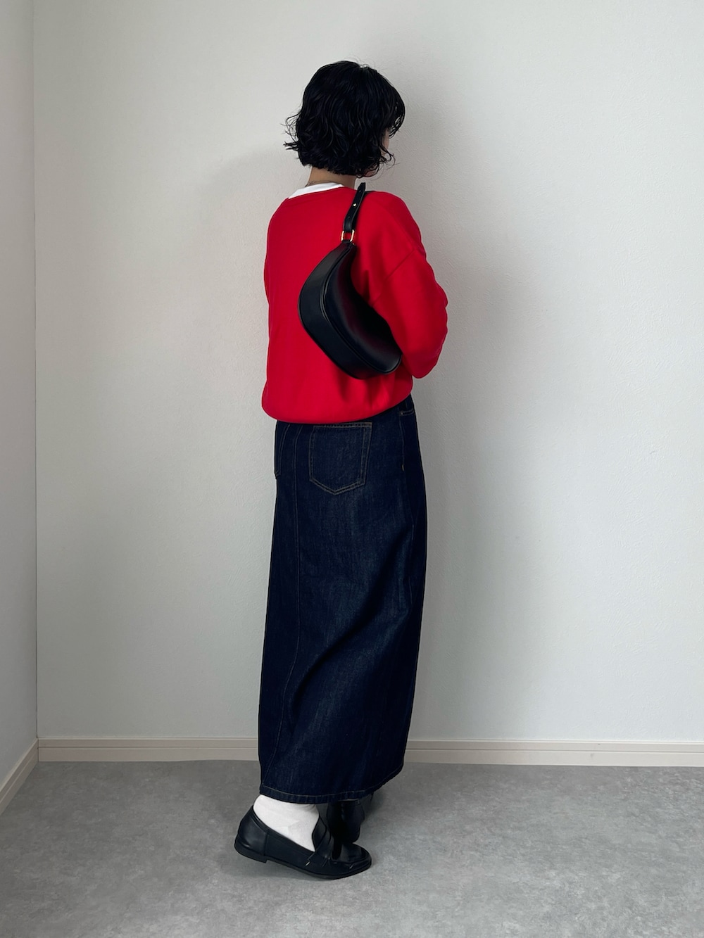 ブラック系のレインシューズ、ブルー系のデニムスカート、レッド系のカーディガン/ボレロを着用したレディースの秋コーディネートの3枚目の写真