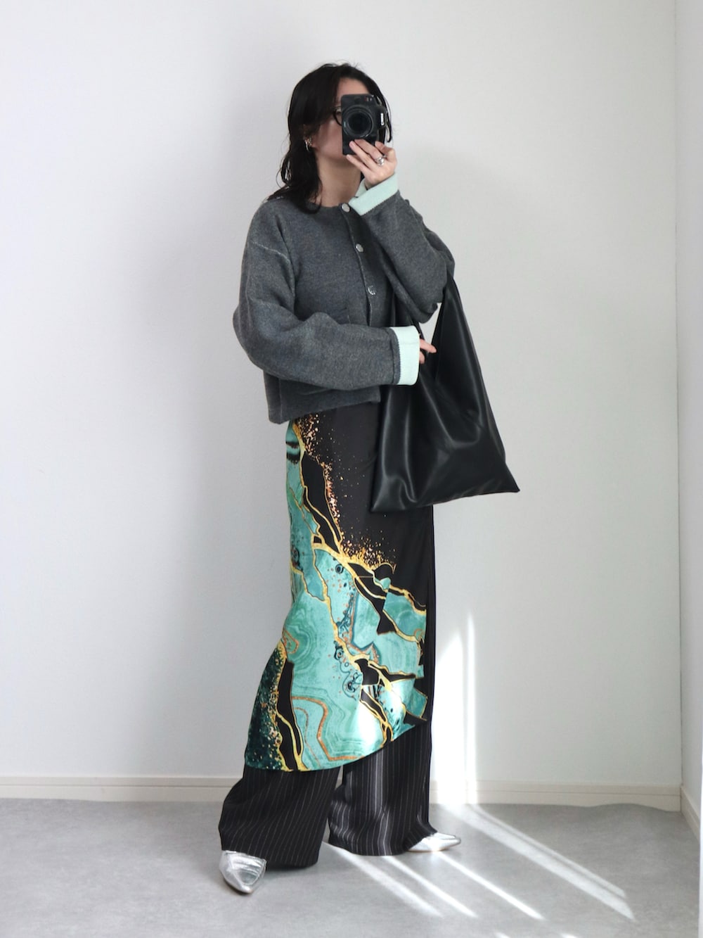 グレー系のカーディガン/ボレロ、ブラック系のスラックス、ブラック系のトートバッグを着用したレディースの秋コーディネートの2枚目の写真