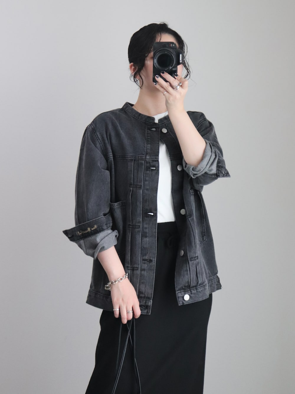 ブラック系のスカート、ブラック系のデニムジャケット、ホワイト系のTシャツ/カットソーを着用したレディースの秋コーディネートの5枚目の写真