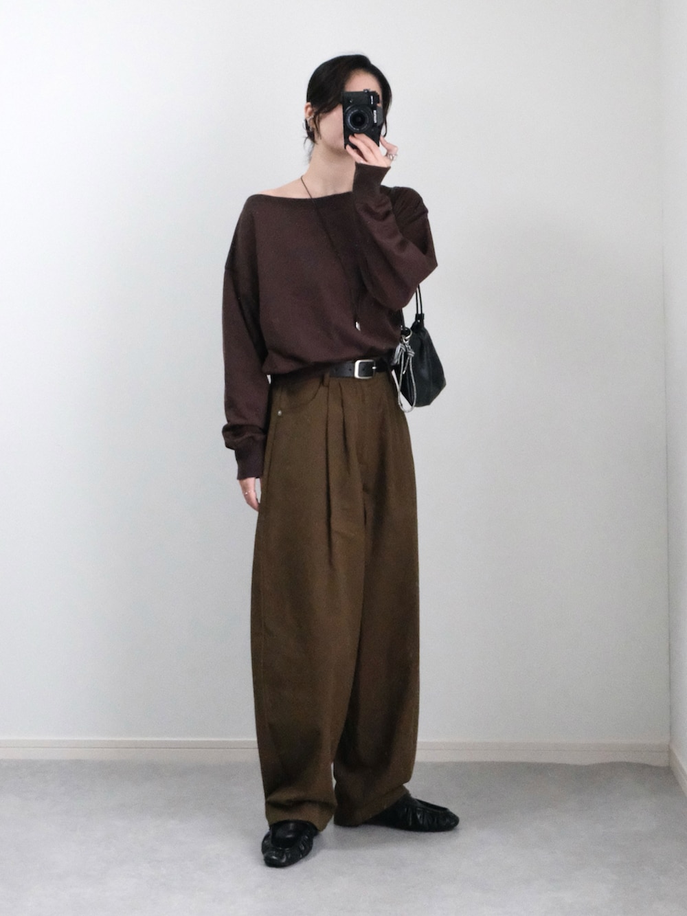 ブラウン系のスウェット、ブラウン系のその他パンツ、ブラック系のハンドバッグを着用したレディースの秋コーディネートの2枚目の写真