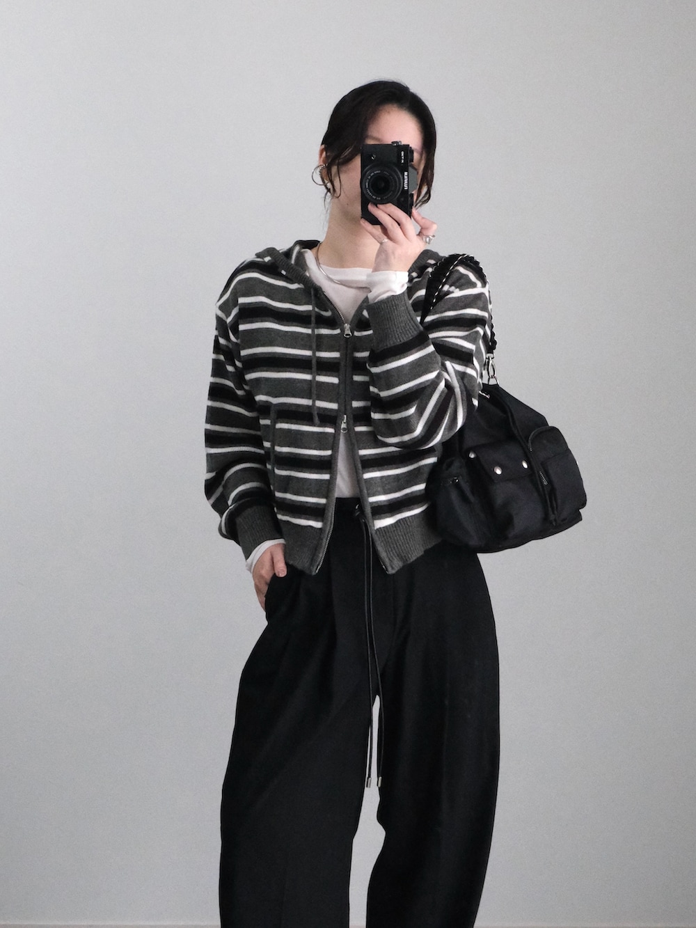 グレー系のパーカー、ブラック系のブーツ、ブラック系のTシャツ/カットソーを着用したレディースの秋コーディネートの2枚目の写真