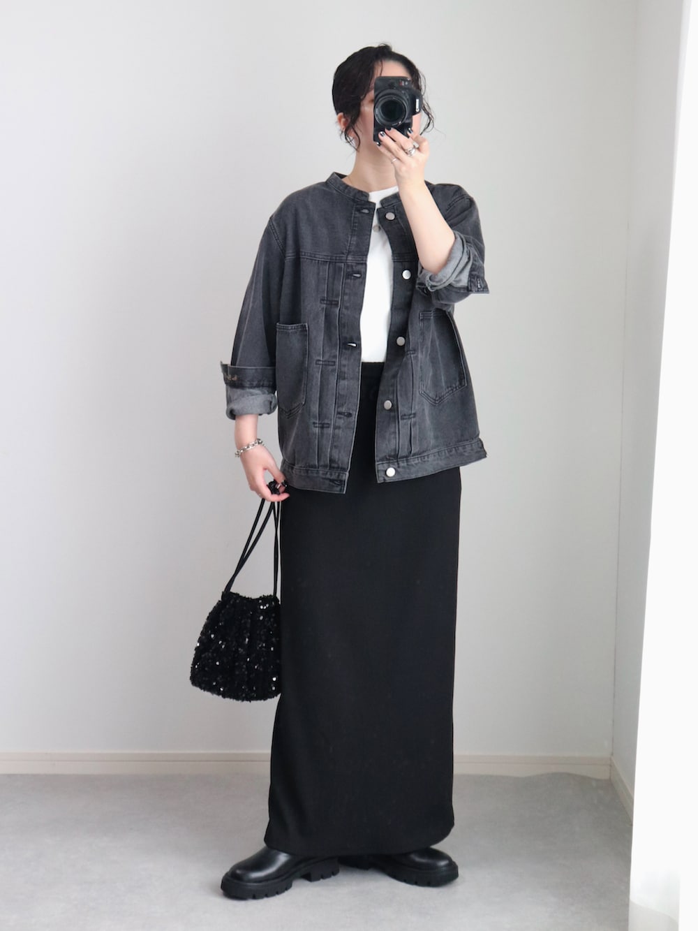 ブラック系のスカート、ブラック系のデニムジャケット、ホワイト系のTシャツ/カットソーを着用したレディースの秋コーディネートの4枚目の写真