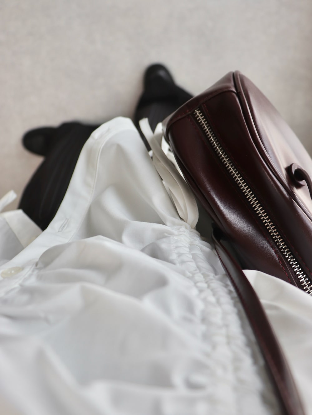 ホワイト系のシャツ/ブラウス、ブラック系のスラックス、レッド系のボストンバッグを着用したレディースの夏コーディネートの3枚目の写真