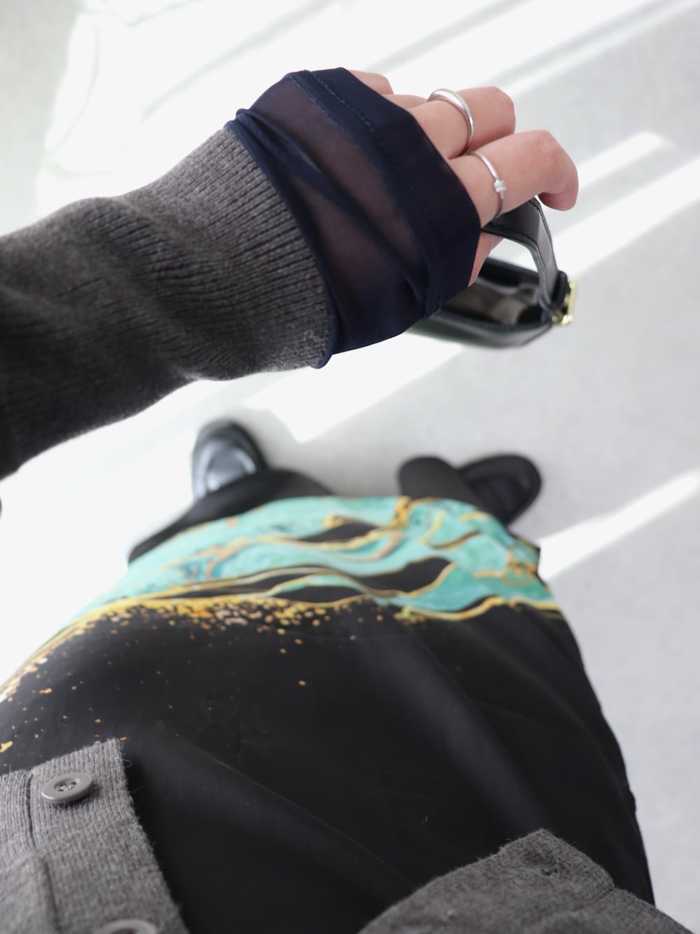 グレー系のカーディガン/ボレロ、ブラック系のスカート、ブラック系のハンドバッグを着用したレディースの冬コーディネートの4枚目の写真