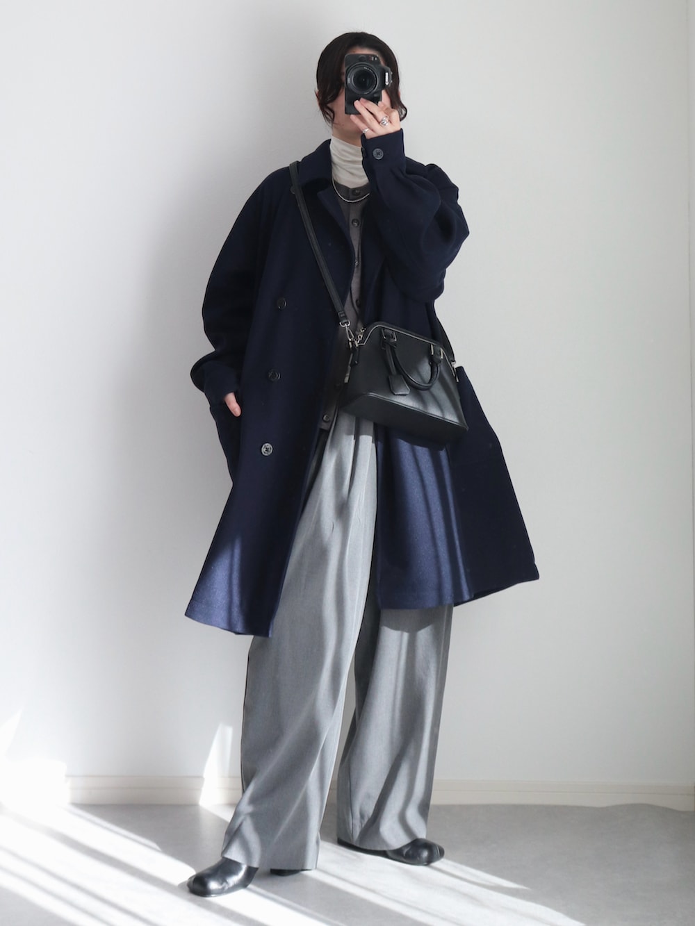 グレー系のカーディガン/ボレロ、グレー系のスラックス、ブルー系のピーコートを着用したレディースの冬コーディネートの3枚目の写真