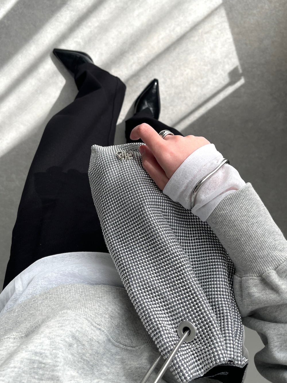 ブラック系のその他パンツ、ブラック系のパンプス、シルバー系のショルダーバッグを着用したレディースの春コーディネートの2枚目の写真