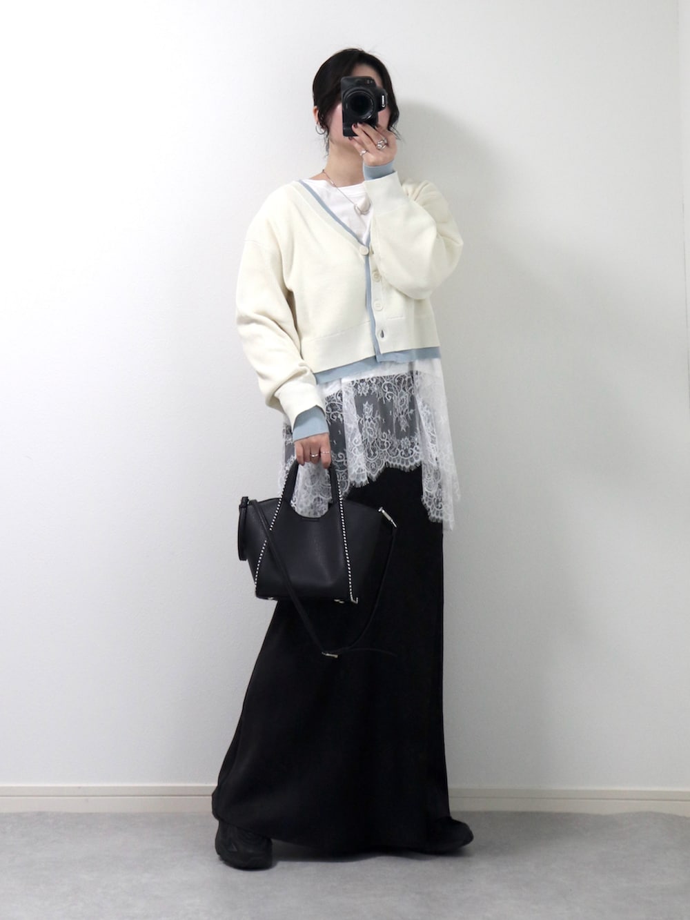 ホワイト系のカーディガン/ボレロ、ホワイト系のTシャツ/カットソー、ブラック系のスカートを着用したレディースの春コーディネートの2枚目の写真