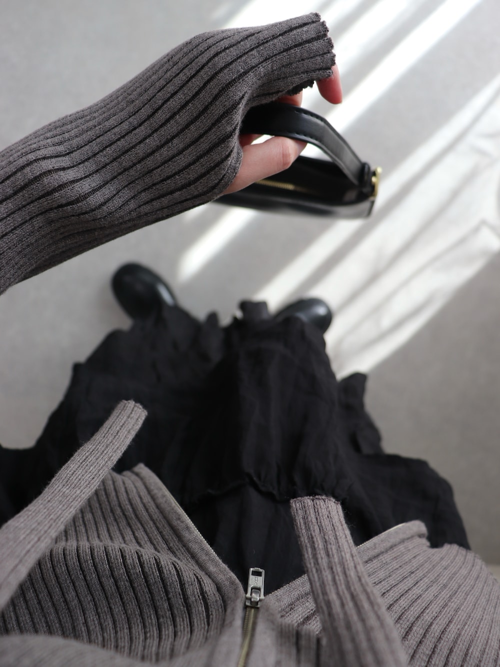 グレー系のカーディガン/ボレロ、ブラック系のハンドバッグ、ブラック系のブーツを着用したレディースの春コーディネートの3枚目の写真