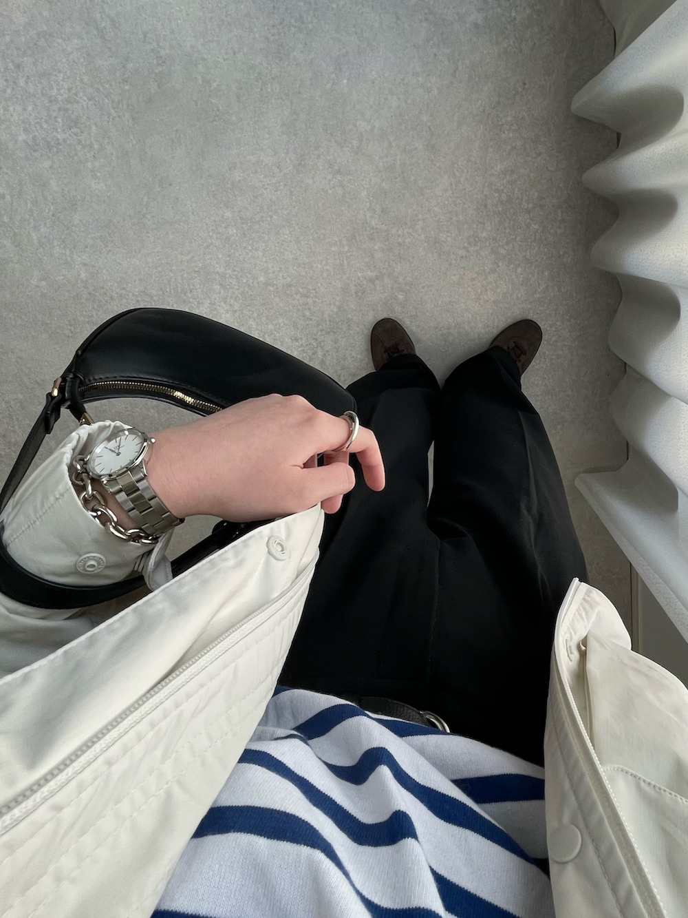 グレー系のスラックス、ブルー系のTシャツ/カットソー、ホワイト系のブルゾンを着用したレディースの春コーディネートの3枚目の写真