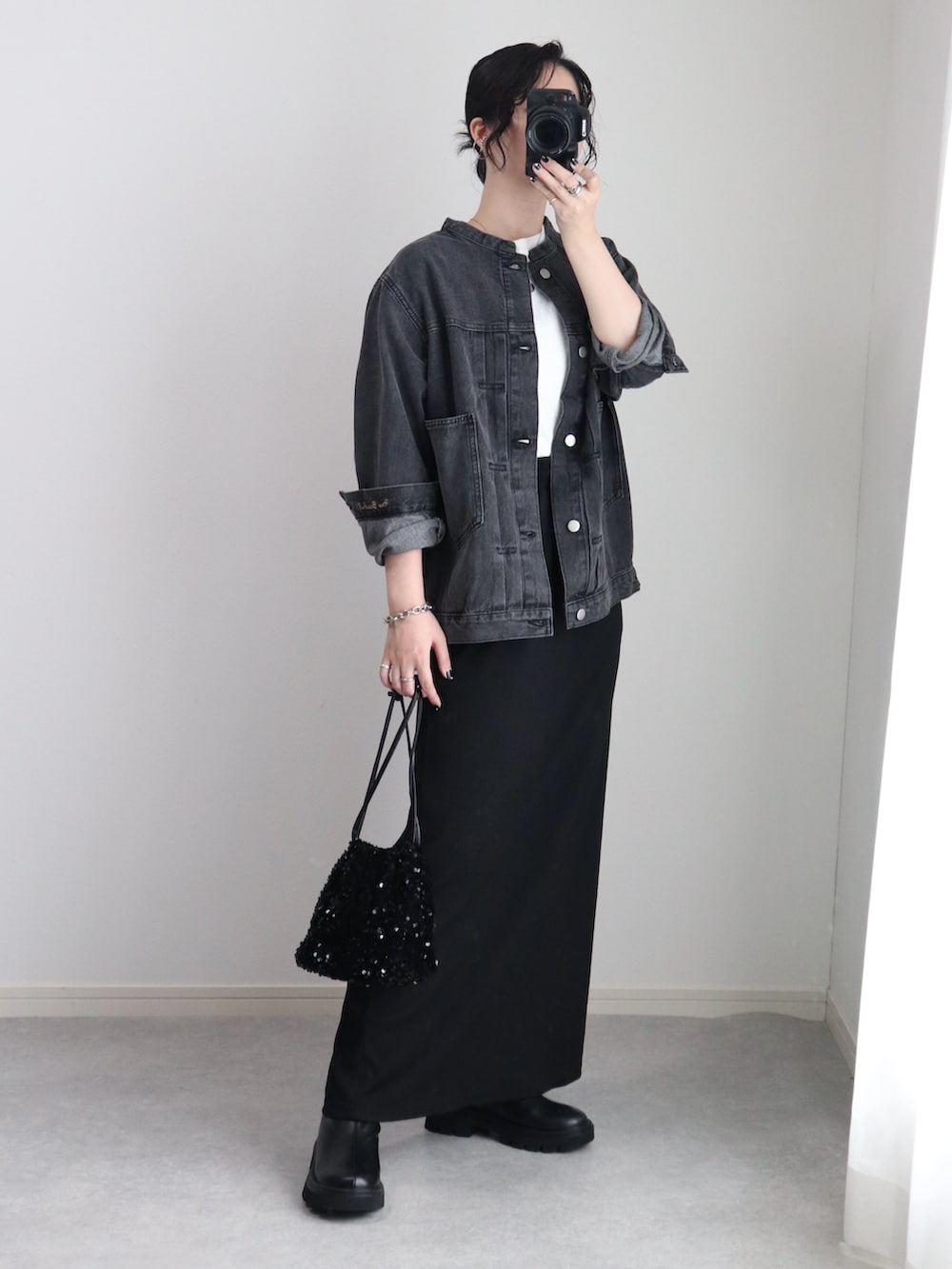 ブラック系のスカート、ブラック系のデニムジャケット、ホワイト系のTシャツ/カットソーを着用したレディースの秋コーディネートの3枚目の写真