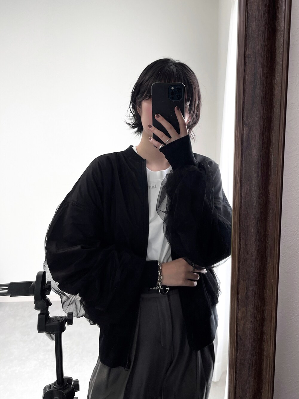 ブラック系のブーツ、グレー系のスラックス、シルバー系のショルダーバッグを着用したレディースの秋コーディネートの4枚目の写真