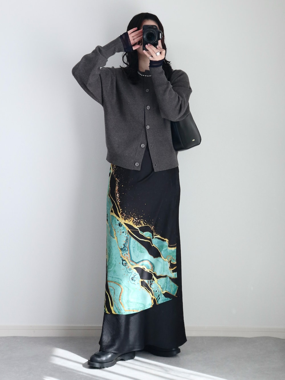 グレー系のカーディガン/ボレロ、ブラック系のスカート、ブラック系のハンドバッグを着用したレディースの冬コーディネートの3枚目の写真