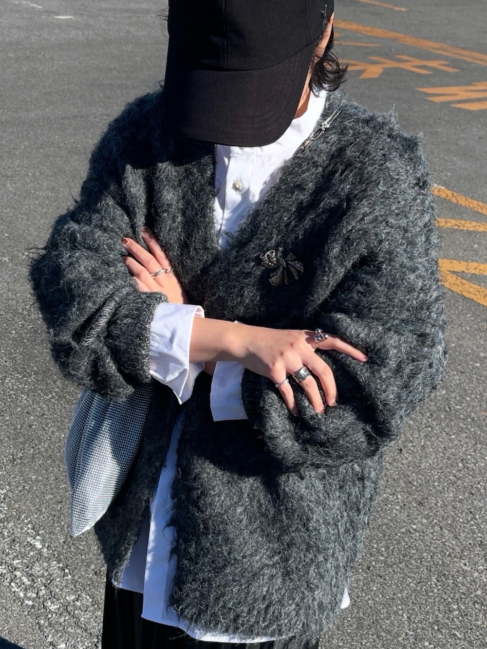 グレー系のカーディガン/ボレロ、ホワイト系のシャツ/ブラウス、シルバー系のショルダーバッグを着用したレディースの冬コーディネートの2枚目の写真