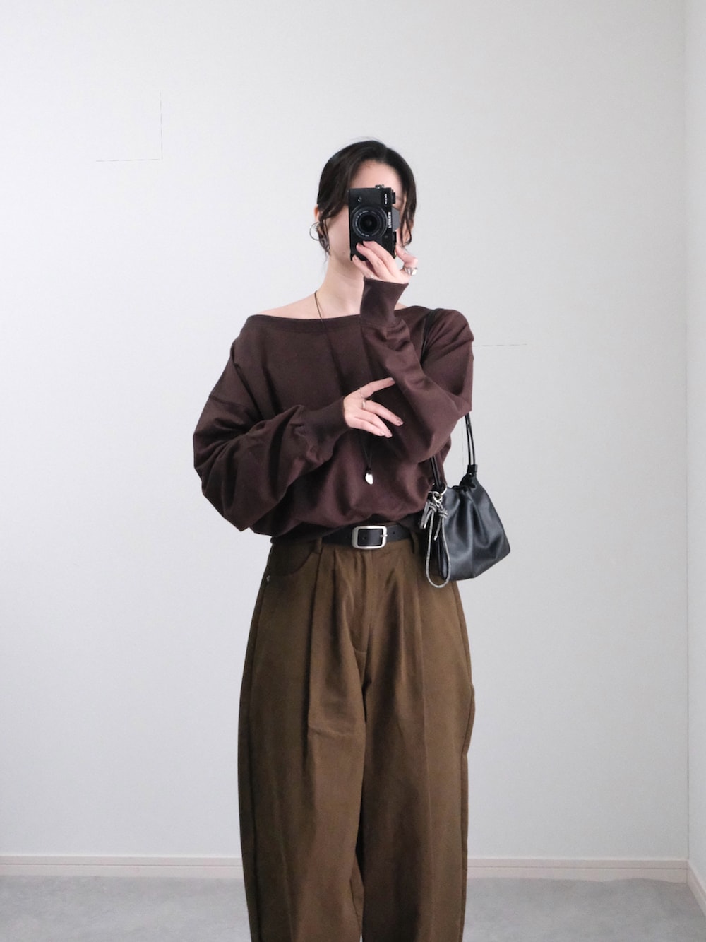 ブラウン系のスウェット、ブラウン系のその他パンツ、ブラック系のハンドバッグを着用したレディースの秋コーディネートの3枚目の写真