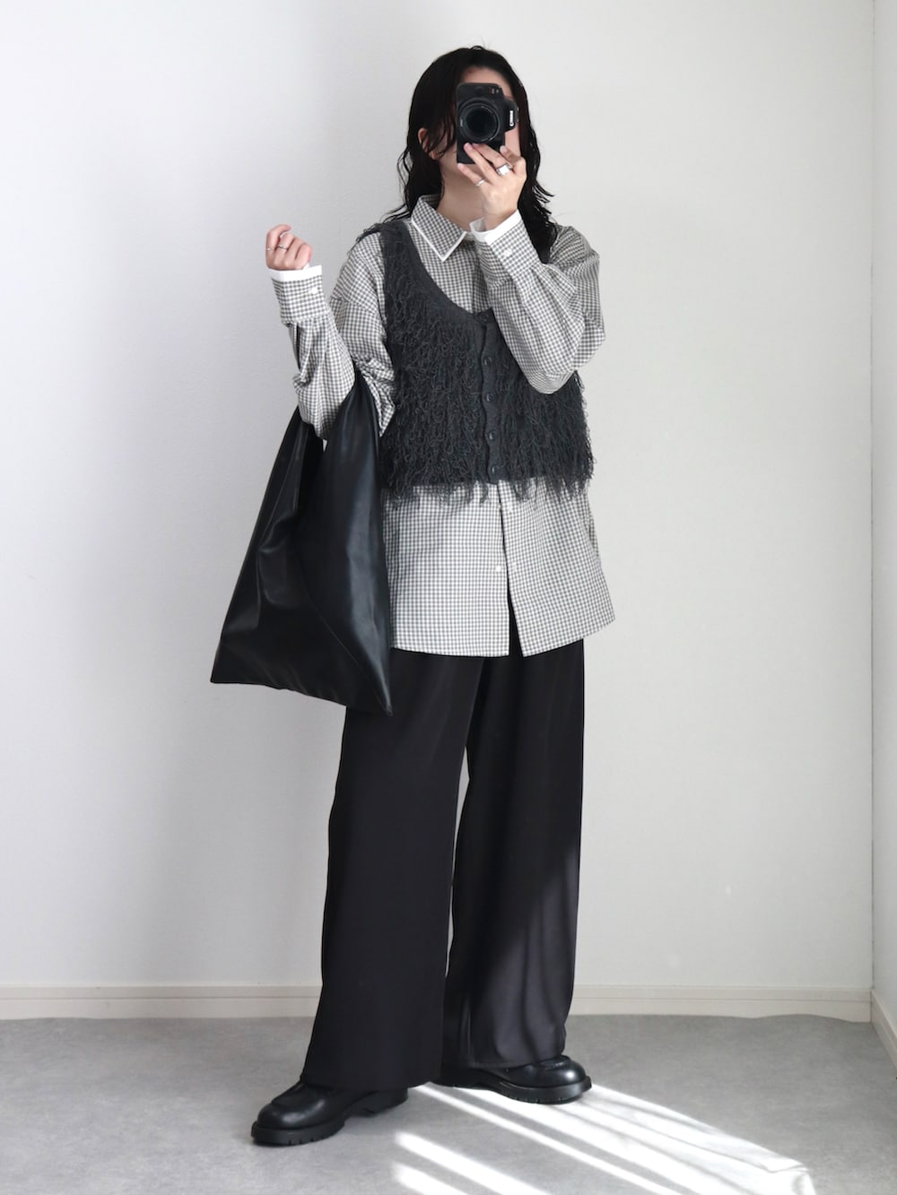 グレー系のベスト、ホワイト系のシャツ/ブラウス、ブラック系のその他パンツを着用したレディースの冬コーディネートの3枚目の写真