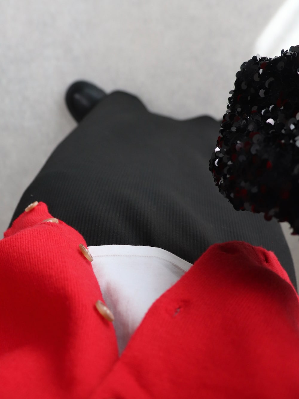 ブラック系のブーツ、レッド系のカーディガン/ボレロ、ホワイト系のTシャツ/カットソーを着用したレディースの秋コーディネートの4枚目の写真