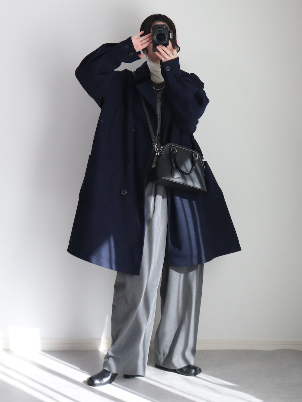 グレー系のカーディガン/ボレロ、グレー系のスラックス、ブルー系のピーコートを着用したレディースの冬コーディネートの4枚目の写真