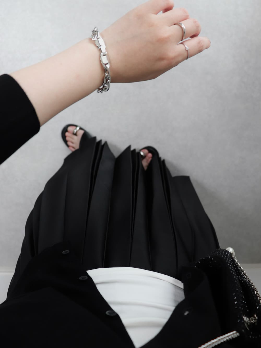 ブラック系のスカート、ブラック系のサンダル、ブラック系のショルダーバッグを着用したレディースの夏コーディネートの2枚目の写真