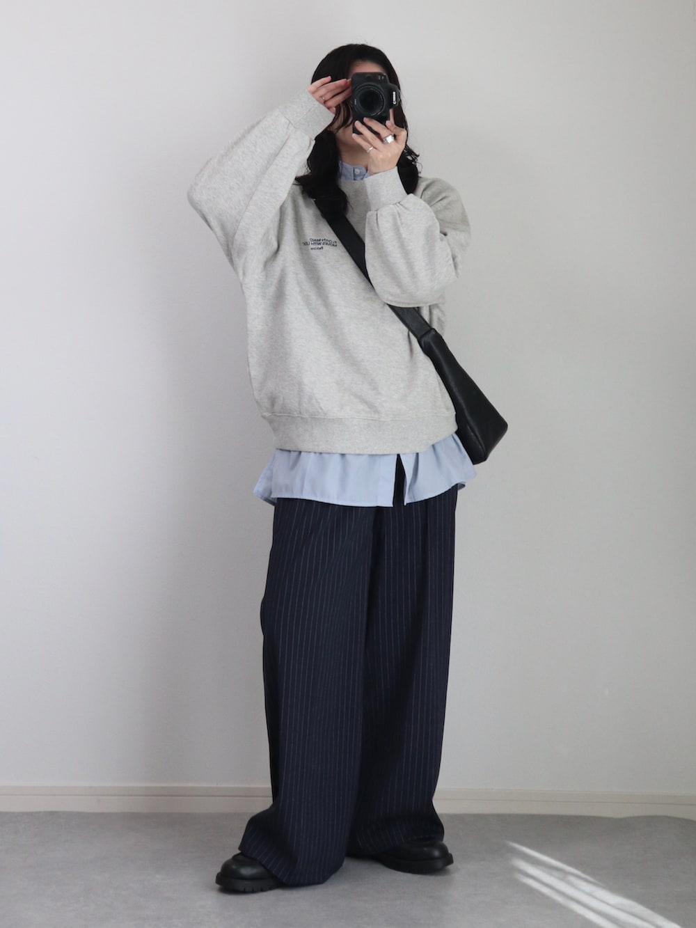 ブラック系のショルダーバッグ、グレー系のスウェット、ブルー系のシャツ/ブラウスを着用したレディースの冬コーディネートの2枚目の写真