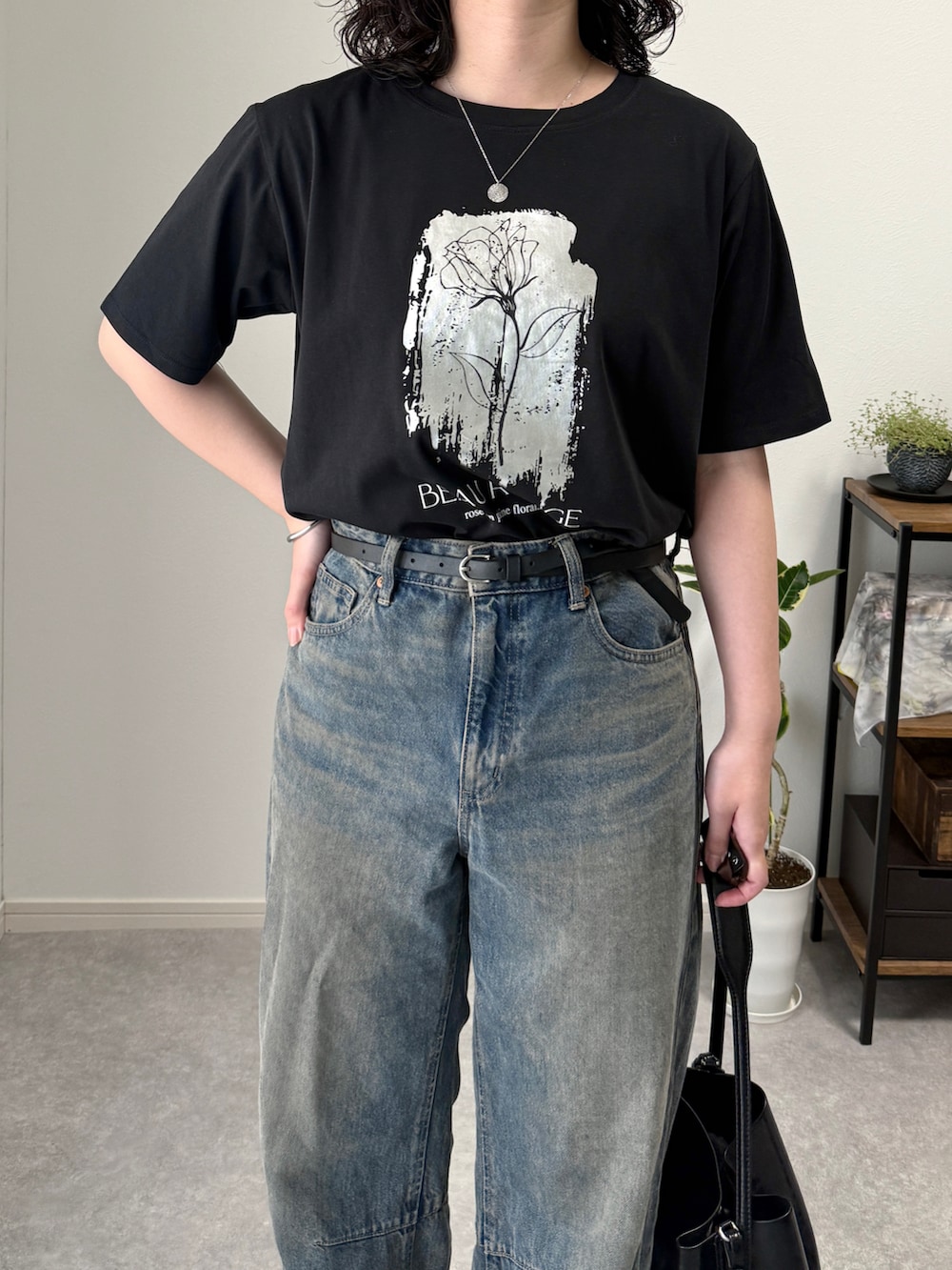 ブルー系のデニムパンツ、シルバー系のローファー、ブラック系のトートバッグを着用したレディースの夏コーディネートの3枚目の写真