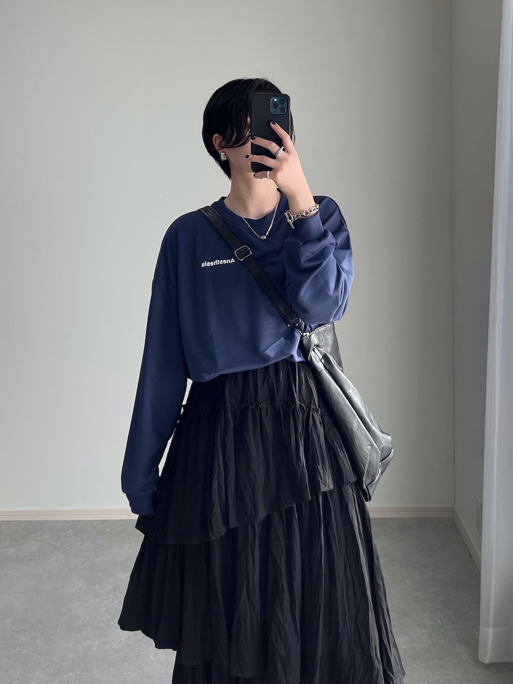 ブラック系のスカート、グレー系のスニーカー、ブラック系のトートバッグを着用したレディースの春コーディネートの4枚目の写真