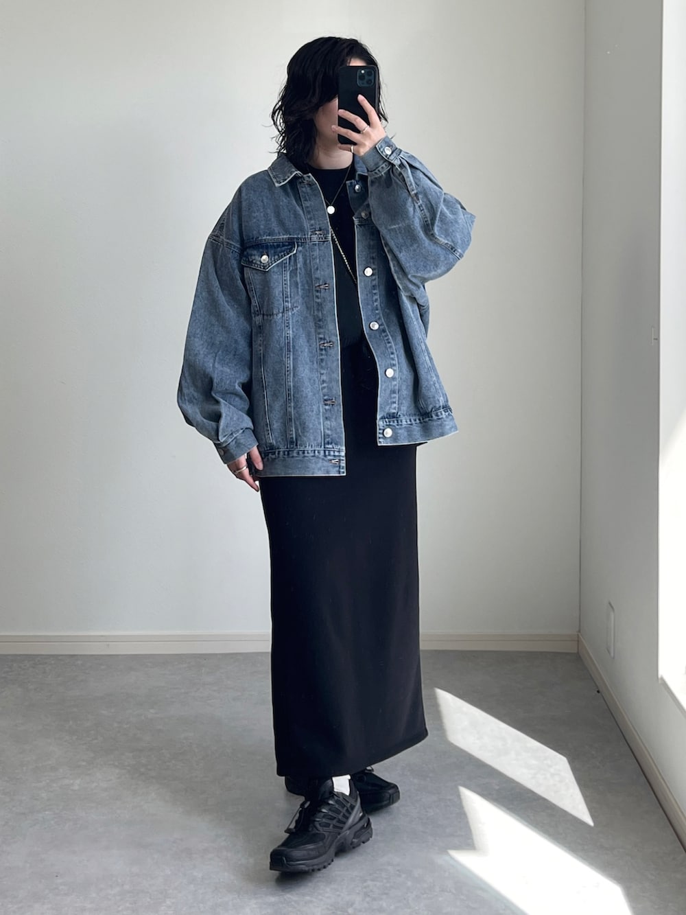 ブラック系のショルダーバッグ、ブラック系のニット/セーター、ブルー系のデニムジャケットを着用したレディースの冬コーディネートの2枚目の写真