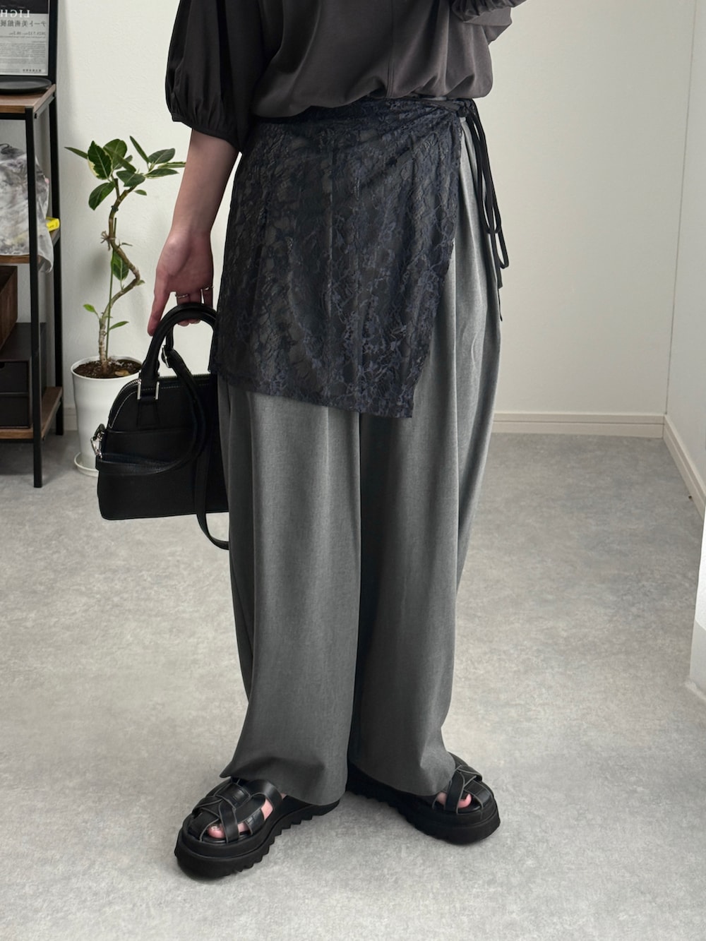 ブラック系のTシャツ/カットソー、グレー系のスラックス、ブラック系のショルダーバッグを着用したレディースの夏コーディネートの4枚目の写真