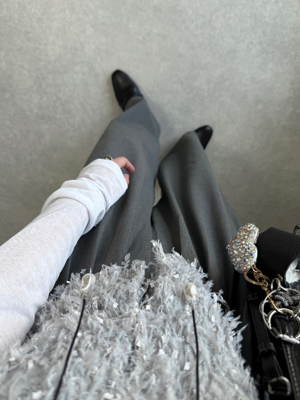 グレー系のスラックス、グレー系のベスト、ホワイト系のTシャツ/カットソーを着用したレディースの春コーディネートの3枚目の写真