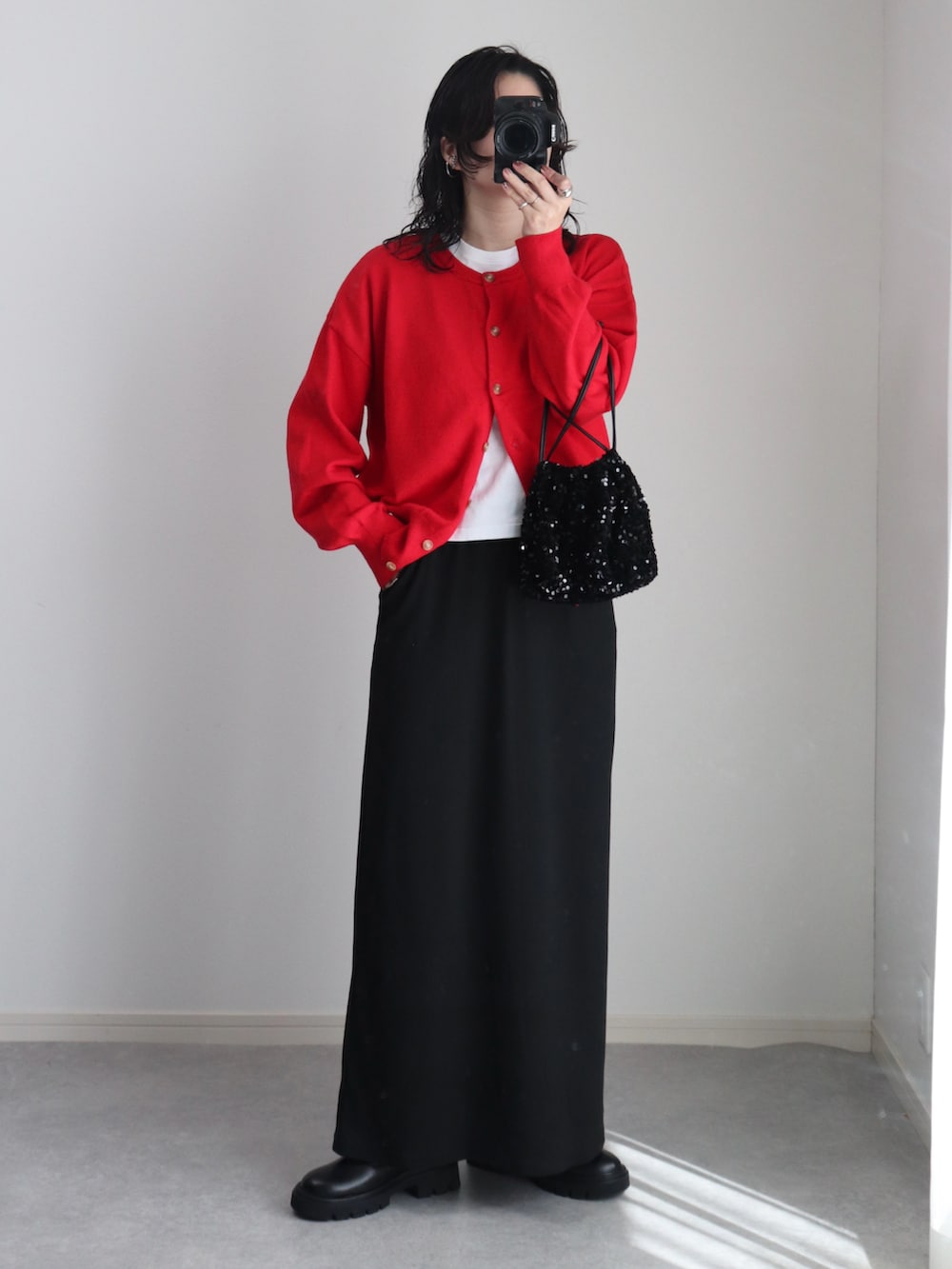 ブラック系のブーツ、レッド系のカーディガン/ボレロ、ホワイト系のTシャツ/カットソーを着用したレディースの秋コーディネートの3枚目の写真