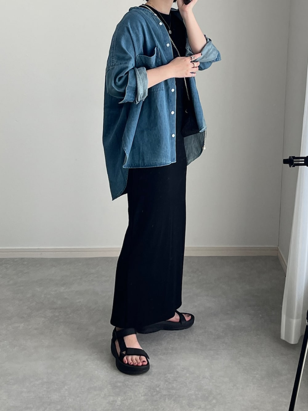 ブラック系のサンダル、ブラック系のワンピース、ブラック系のショルダーバッグを着用したレディースの秋コーディネートの5枚目の写真