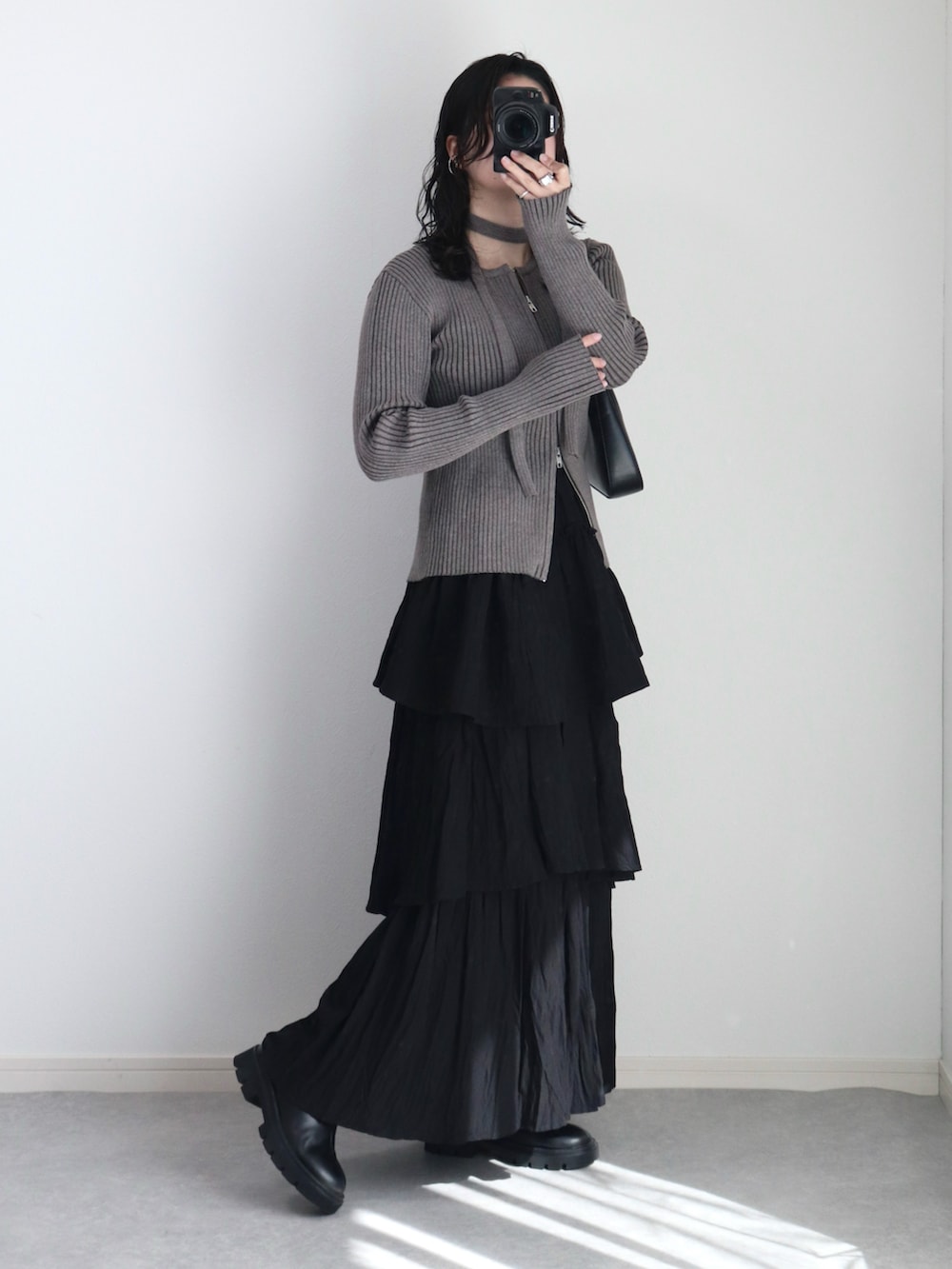 グレー系のカーディガン/ボレロ、ブラック系のハンドバッグ、ブラック系のブーツを着用したレディースの春コーディネートの2枚目の写真