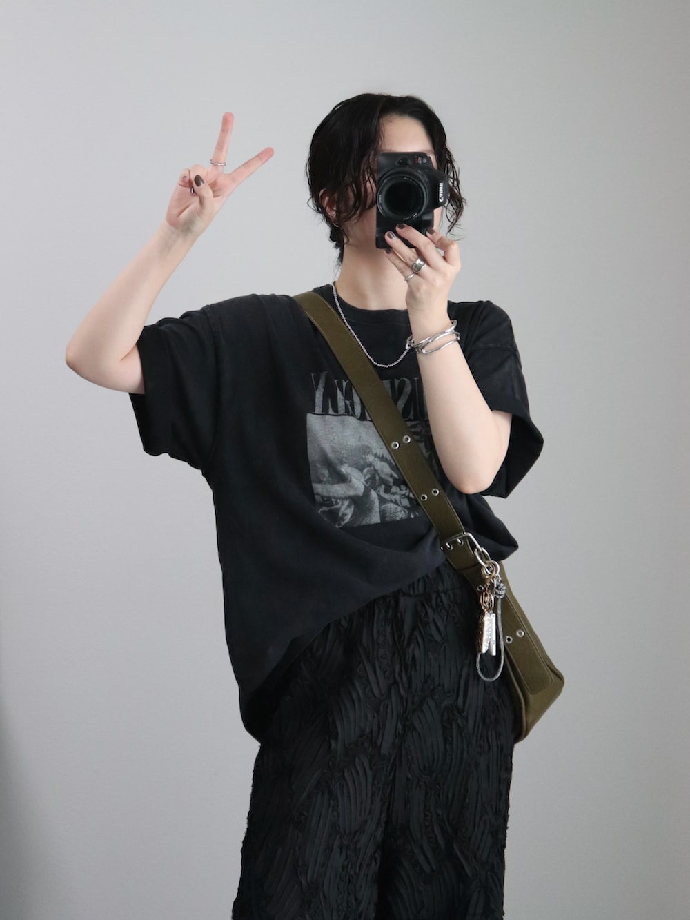 ブラック系のTシャツ/カットソー、ブラック系のサンダル、グリーン系のショルダーバッグを着用したレディースの夏コーディネートの2枚目の写真