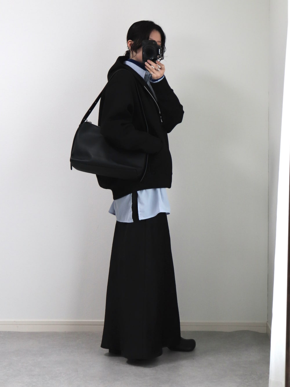 ブラック系のショルダーバッグ、ブラック系のパーカー、ブルー系のシャツ/ブラウスを着用したレディースの冬コーディネートの2枚目の写真