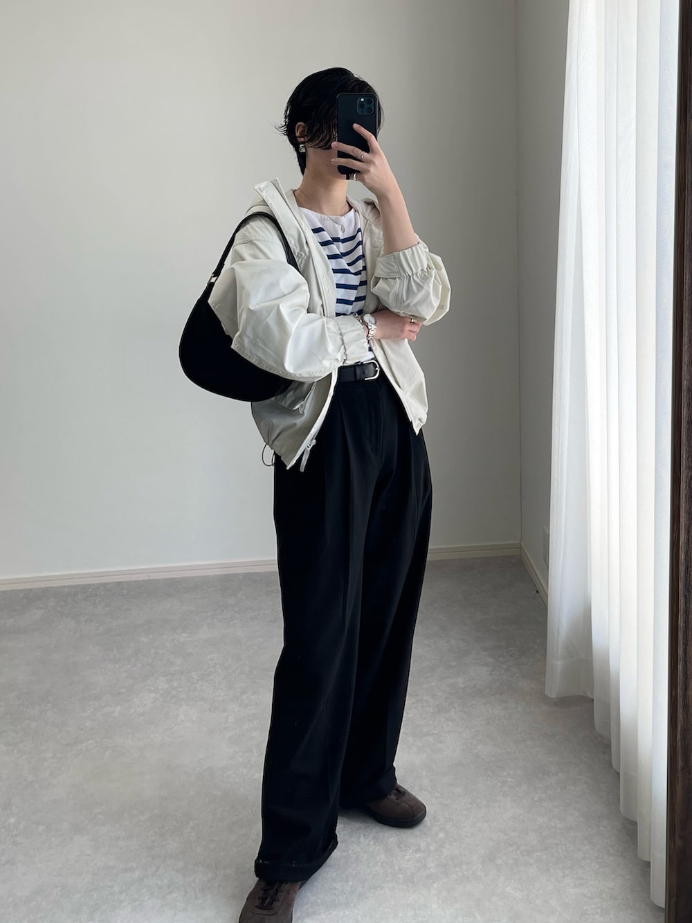 グレー系のスラックス、ブルー系のTシャツ/カットソー、ホワイト系のブルゾンを着用したレディースの春コーディネートの2枚目の写真