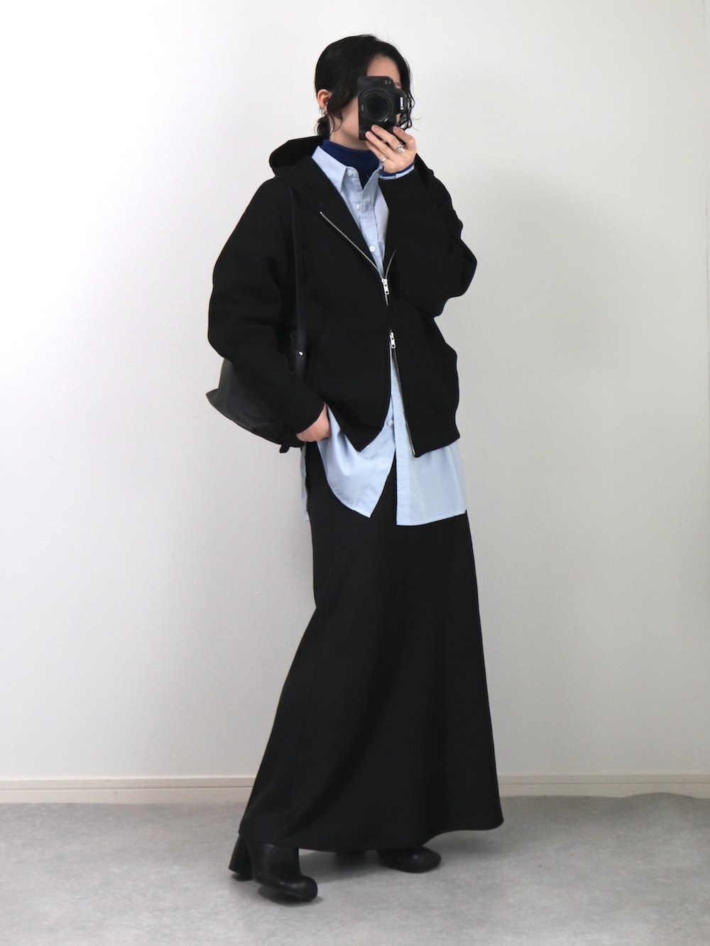 ブラック系のショルダーバッグ、ブラック系のパーカー、ブルー系のシャツ/ブラウスを着用したレディースの冬コーディネートの3枚目の写真